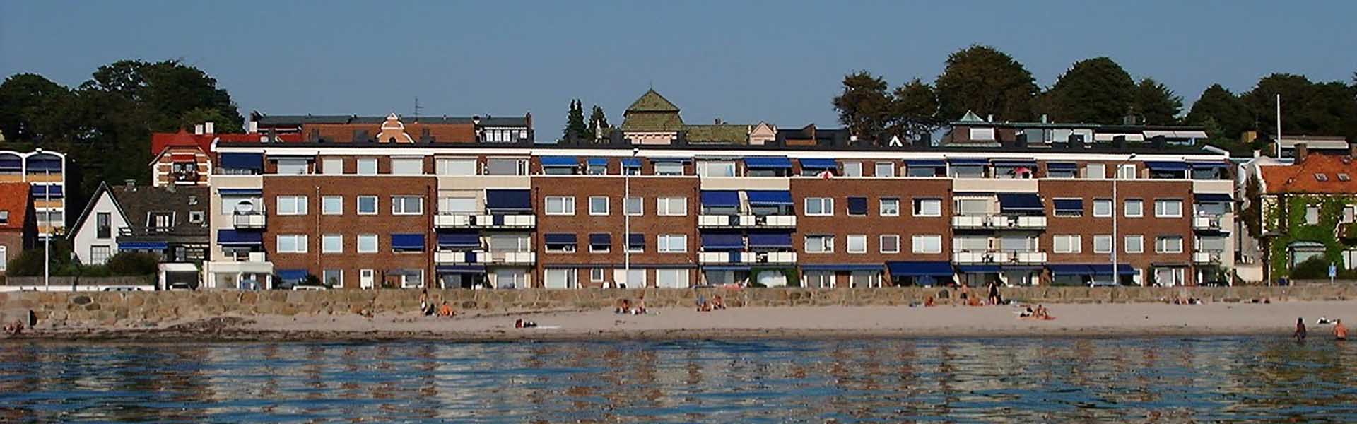 Huset visas från havet  med stranden i framkanten